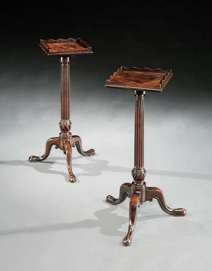 A near pair of mahogany urn stands